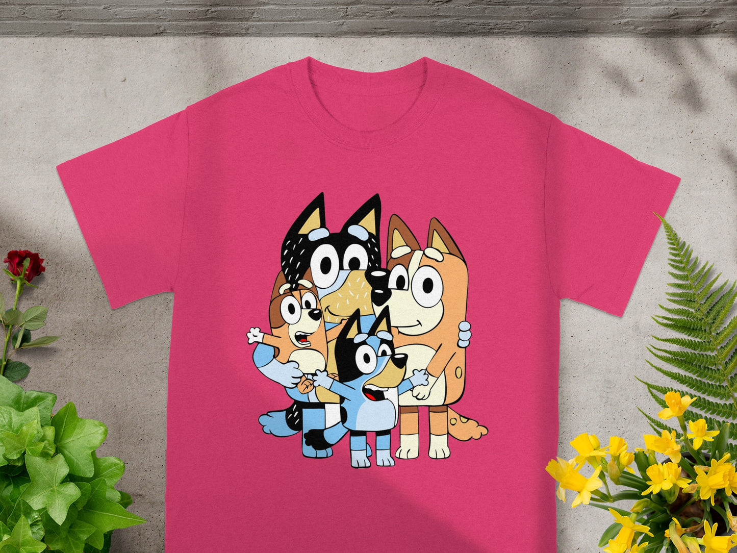 Bluey family characters in a playful pose on a pink t-shirt.