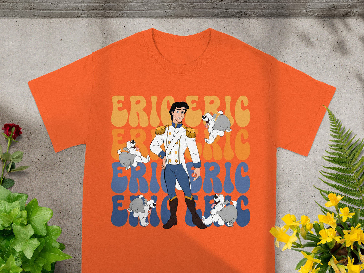 Orange t-shirt featuring Prince Eric and dogs with colorful text.