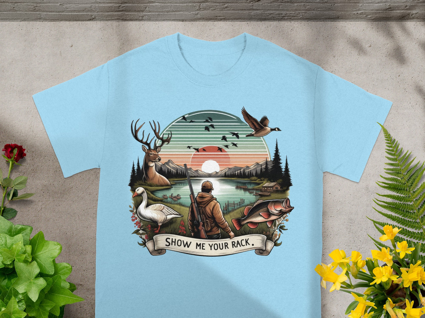 T-shirt graphic of hunter, deer, goose, duck, fish, and lake at sunset.
