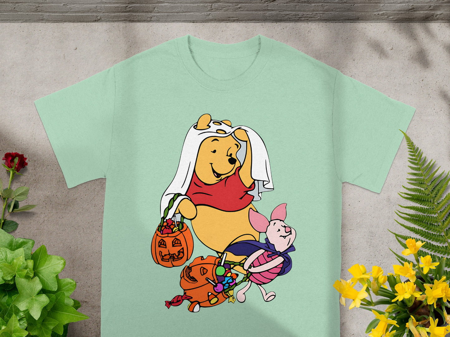Winnie the Pooh and Piglet in Halloween costumes holding candy buckets.