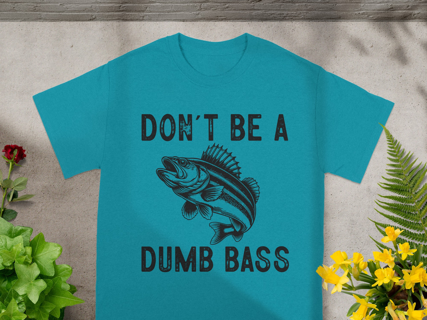 Teal t-shirt with illustration of a bass fish and text "DON'T BE A DUMB BASS".