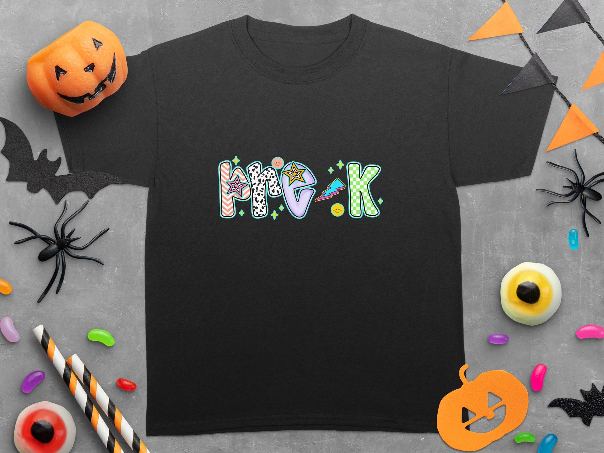 Black t-shirt with "me:k" text in colorful, playful Halloween-themed lettering.