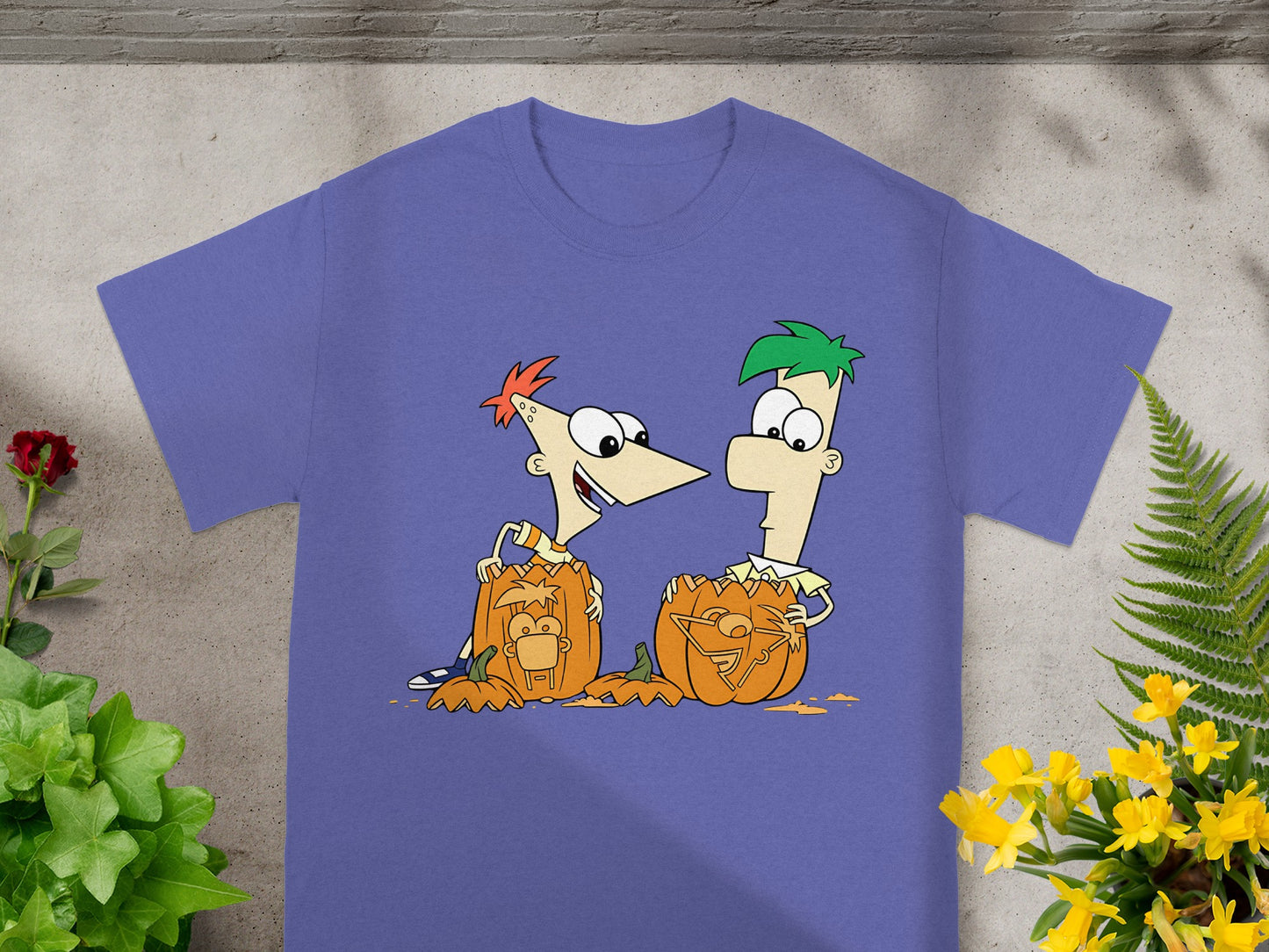 Phineas and Ferb cartoon characters with carved pumpkins on a purple t-shirt.