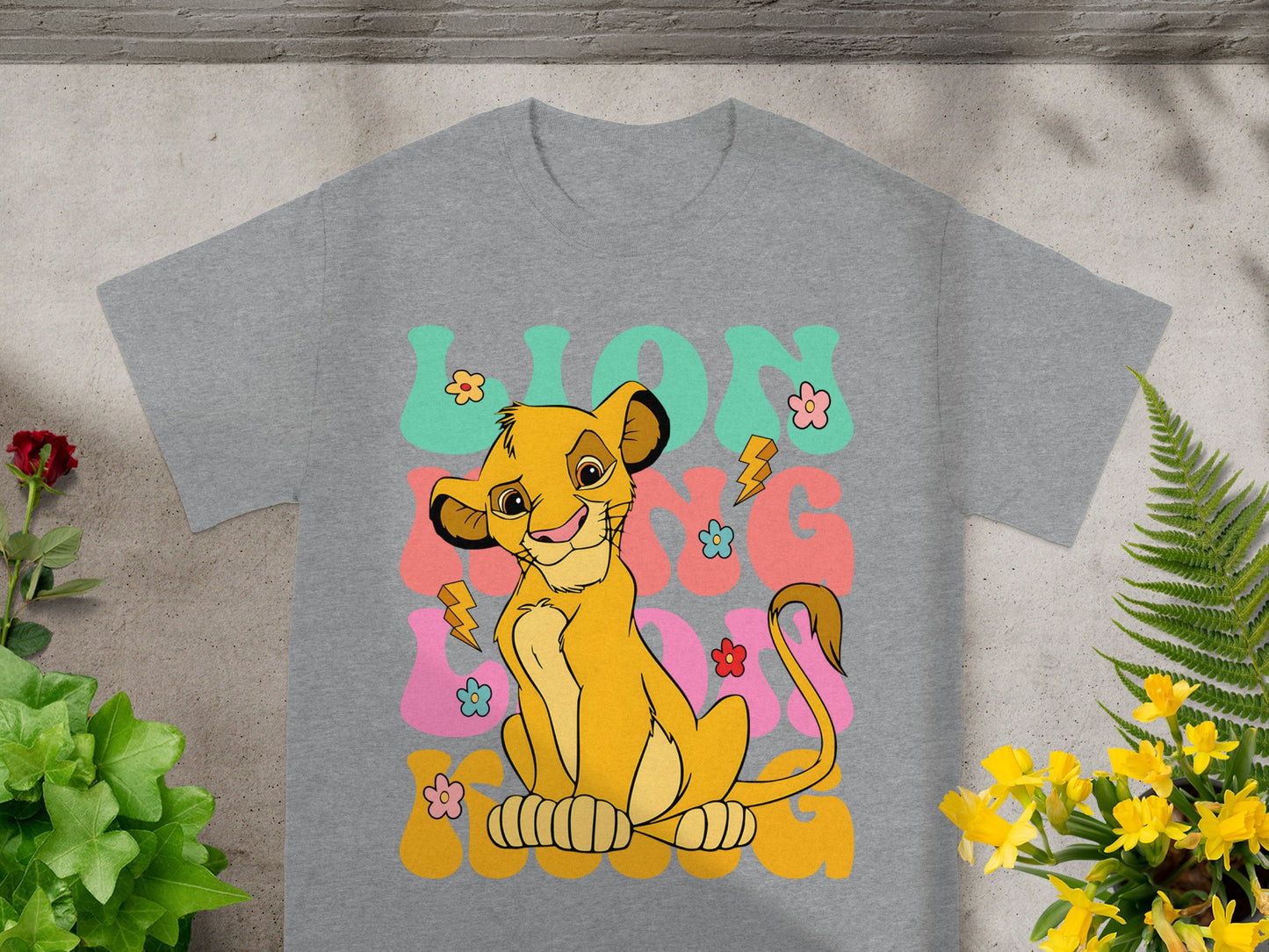 Gray t-shirt with Simba and text "Lion King" in colorful, retro font.