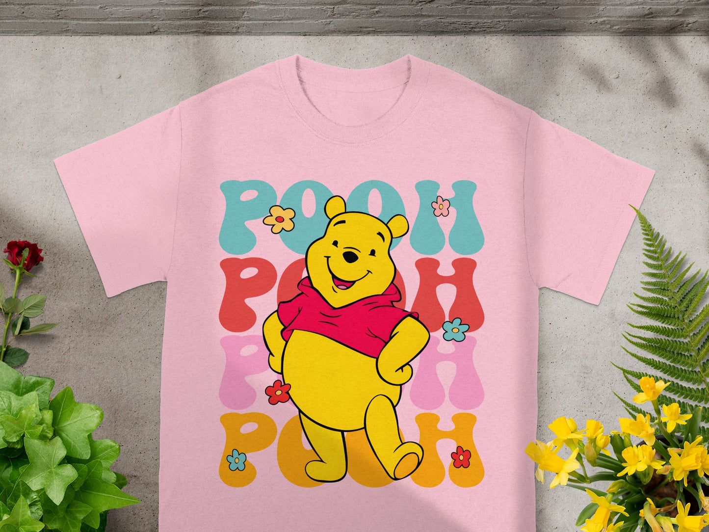 Pink t-shirt with "Pooh" in groovy font and cartoon Winnie the Pooh.