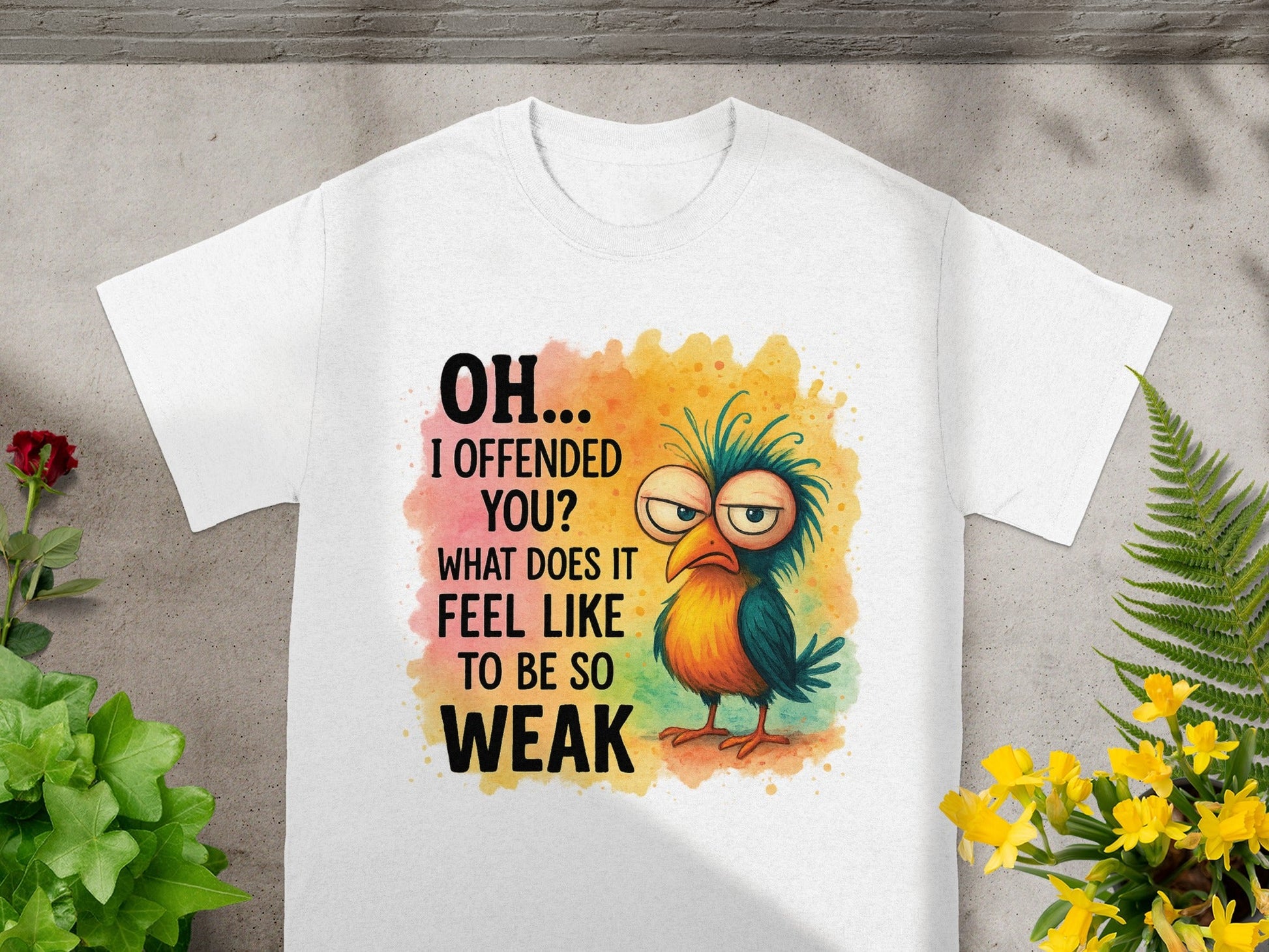 White t-shirt with text "OH... I OFFENDED YOU? WHAT DOES IT FEEL LIKE TO BE SO WEAK" and cartoon bird.