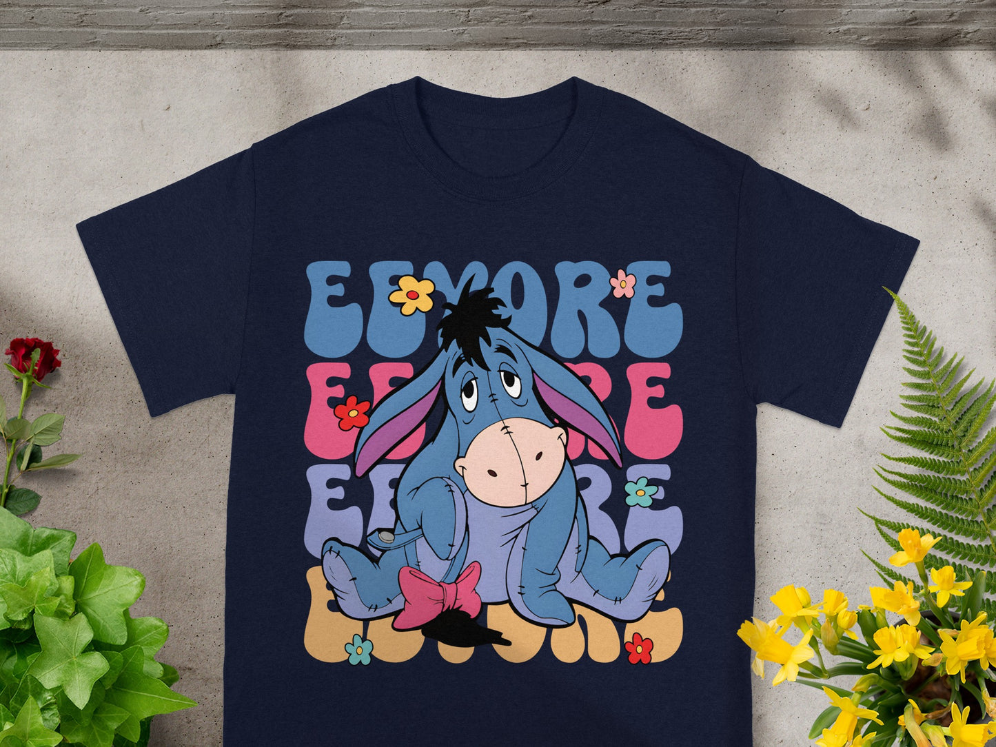 Eeyore sitting with colorful flowers and text.