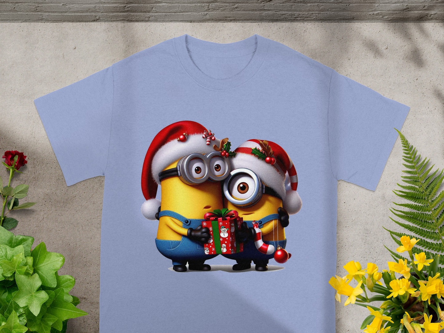 Two Minions in festive Santa hats hold a gift and a candy cane.