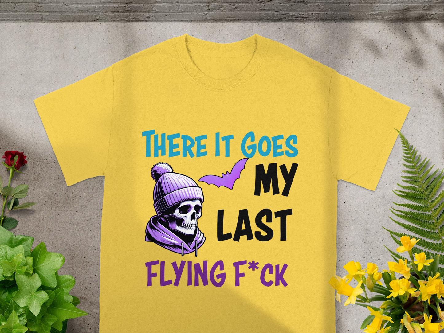Yellow t-shirt with skull, bat, and text "THERE IT GOES MY LAST FLYING F*CK".