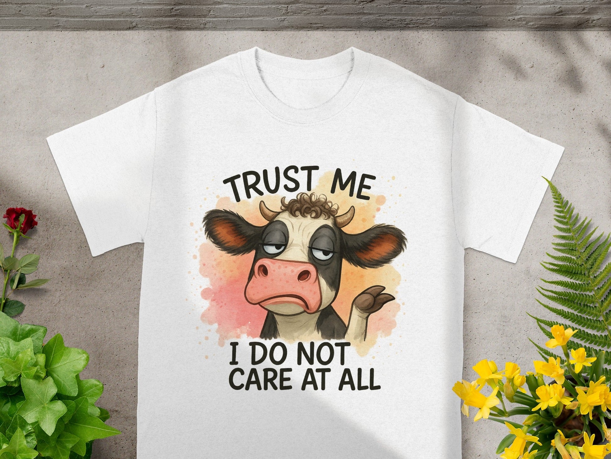 White t-shirt with cartoon cow saying "Trust me I do not care at all."