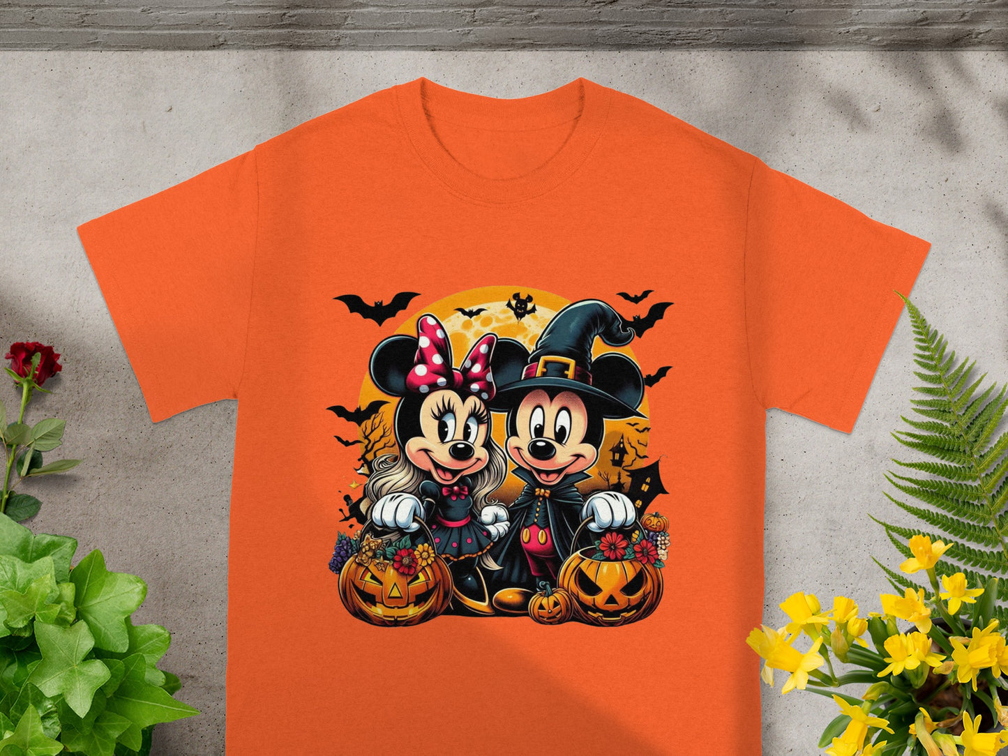 Minnie Mouse and Mickey Mouse in Halloween costumes with pumpkins and bats.