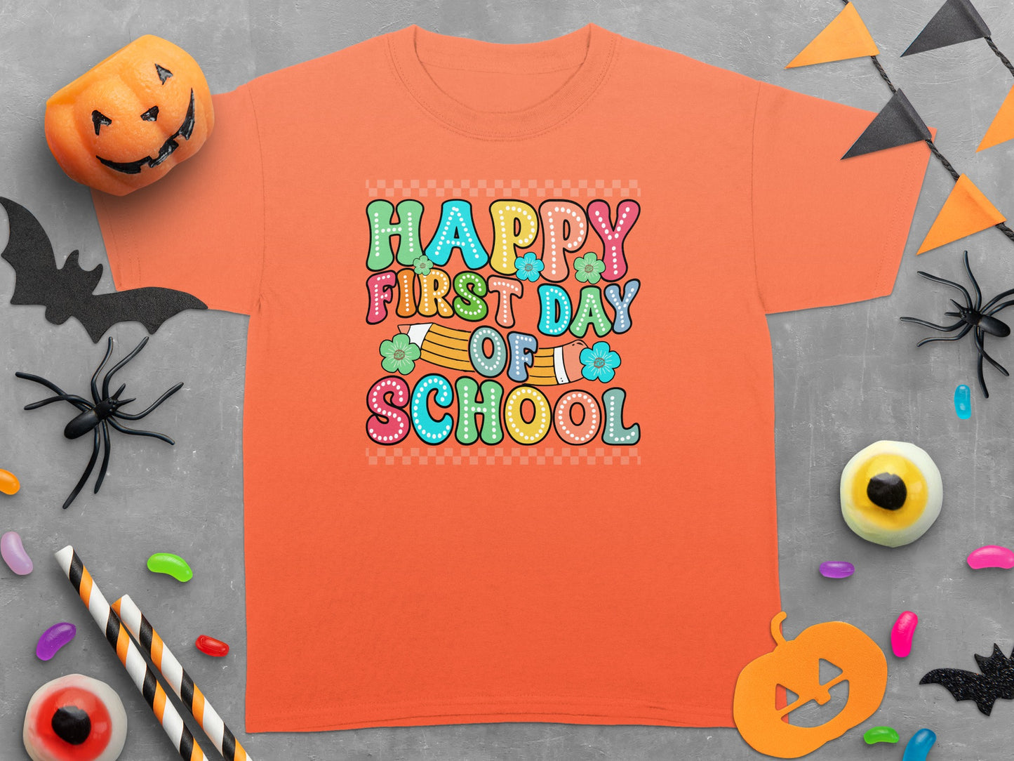 Orange T-shirt with "Happy First Day Of School" in colorful, whimsical lettering.