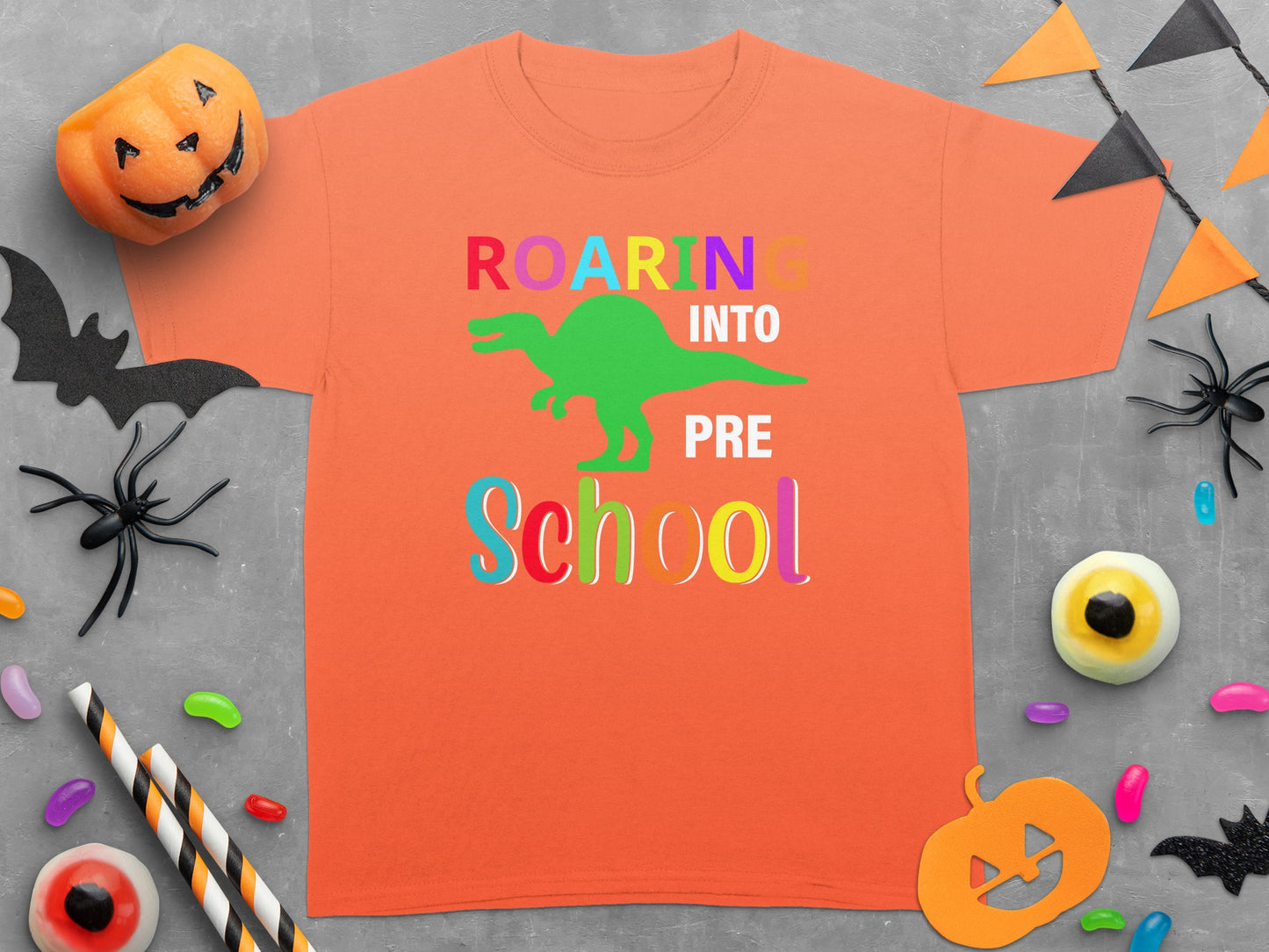 Orange t-shirt with "ROARING INTO PRE SCHOOL" text and a green dinosaur graphic.