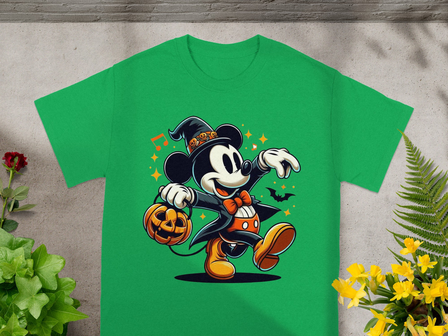 Mickey Mouse in a witch hat holding a jack-o-lantern on a green shirt.