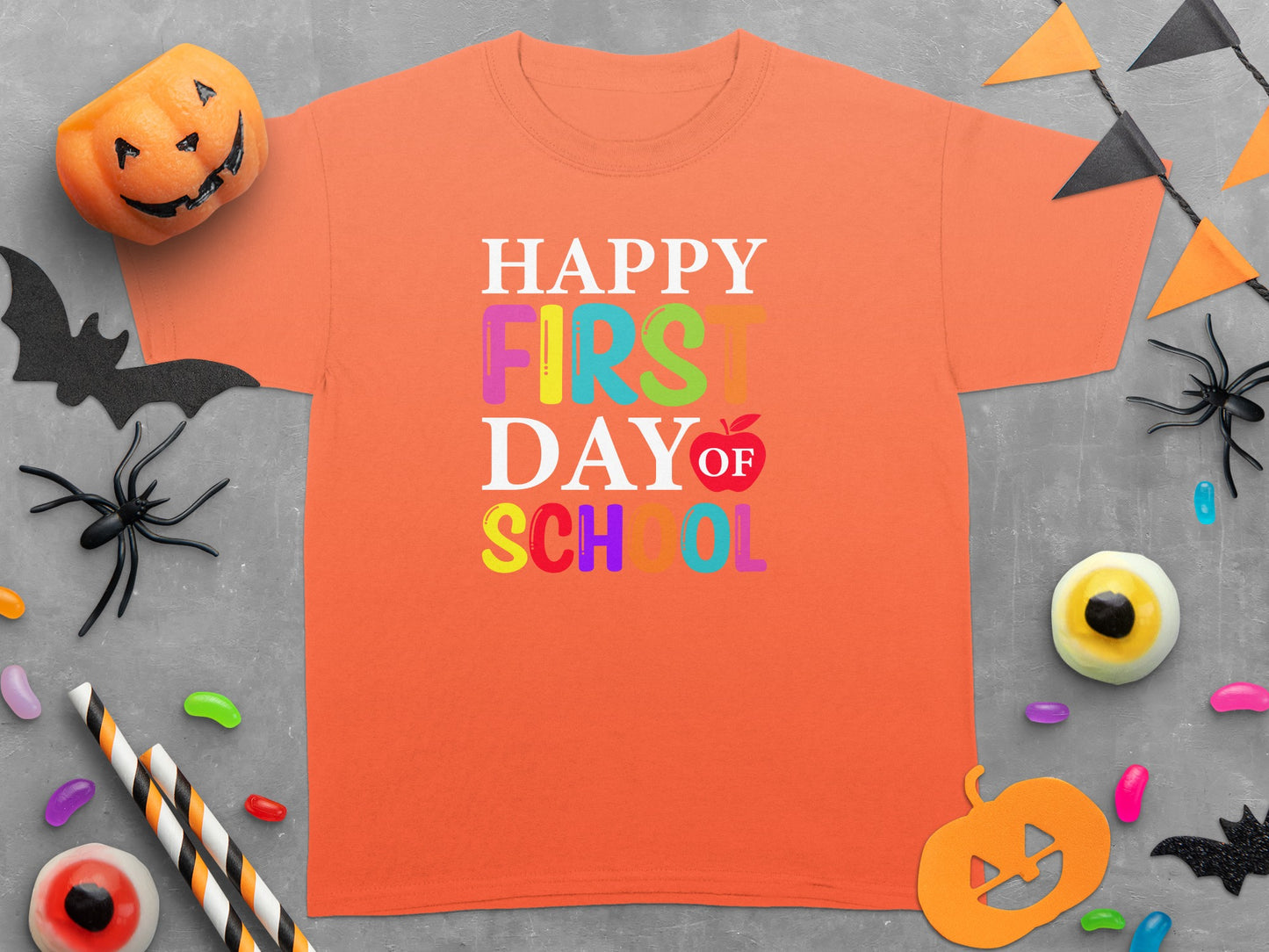 Orange t-shirt with "Happy First Day of School" text and Halloween decorations.