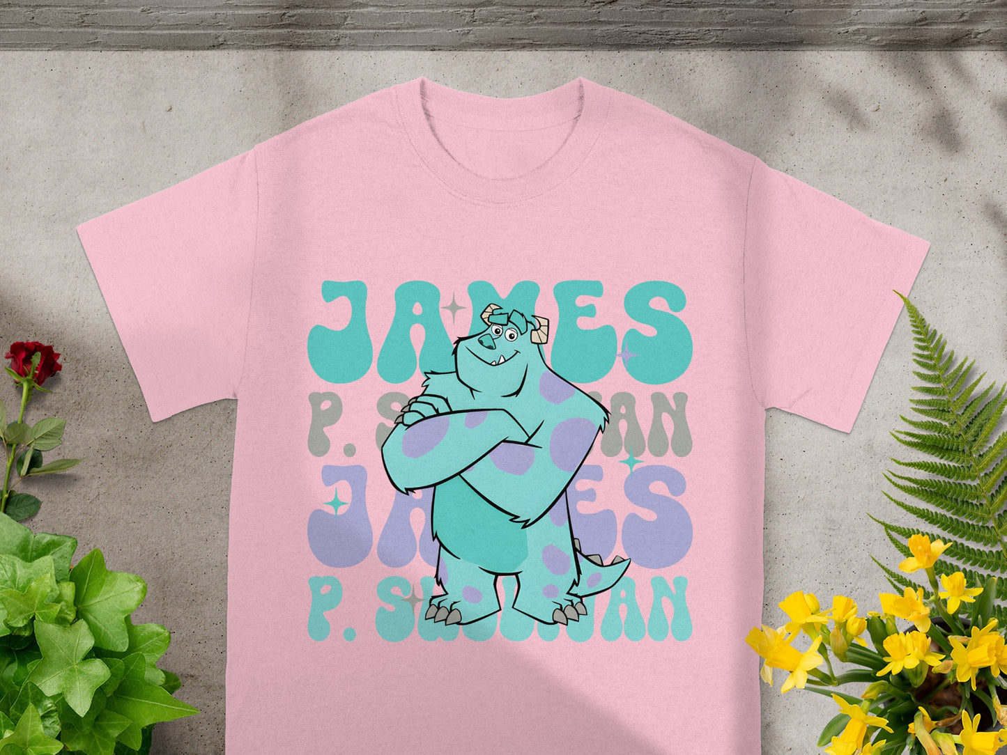 Pink t-shirt with "James P. Sullivan" and Monsters, Inc. Sulley graphic.
