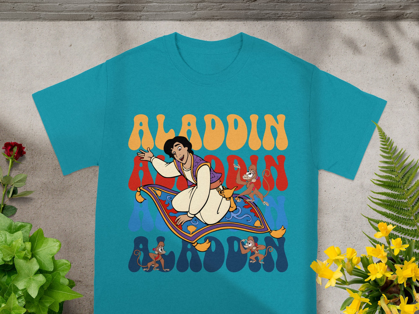 Aladdin character riding magic carpet with Abu monkeys, text reads Aladdin.