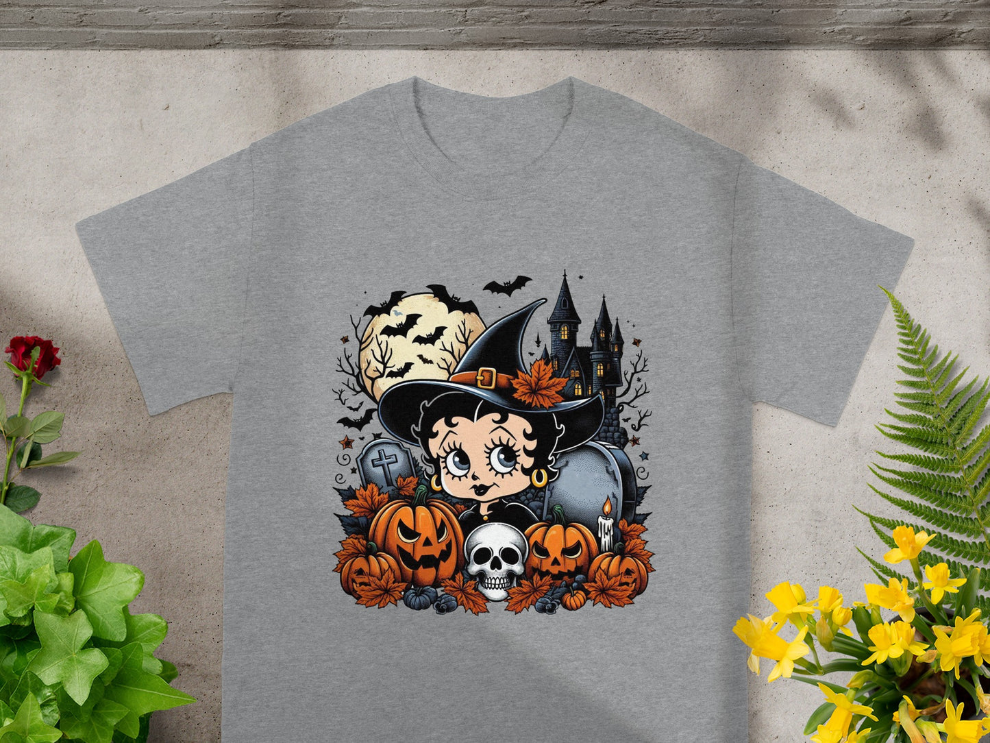 Betty Boop in witch hat with Halloween pumpkins, skull, and haunted castle graphic on grey t-shirt.