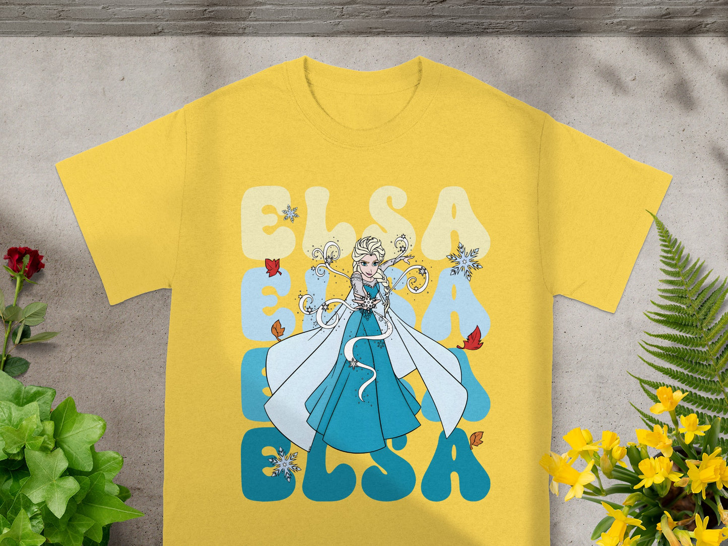 Yellow t-shirt with Elsa from Frozen graphic and text.
