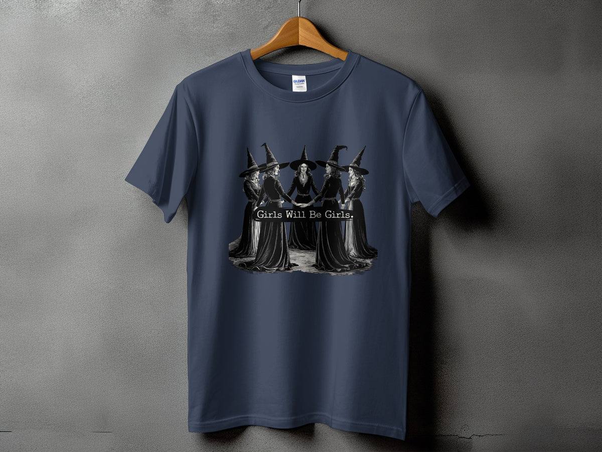 Dark blue t-shirt with five witches in a circle, text reads "Girls Will Be Girls."