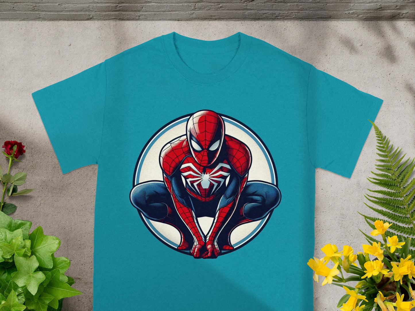 Spider-Man crouches in a comic-style illustration on a teal t-shirt.