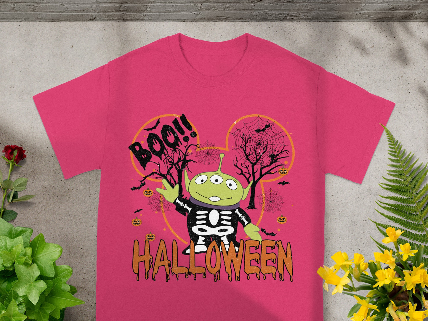 Alien character in skeleton costume with "Boo!" and "Halloween" text on a pink shirt.