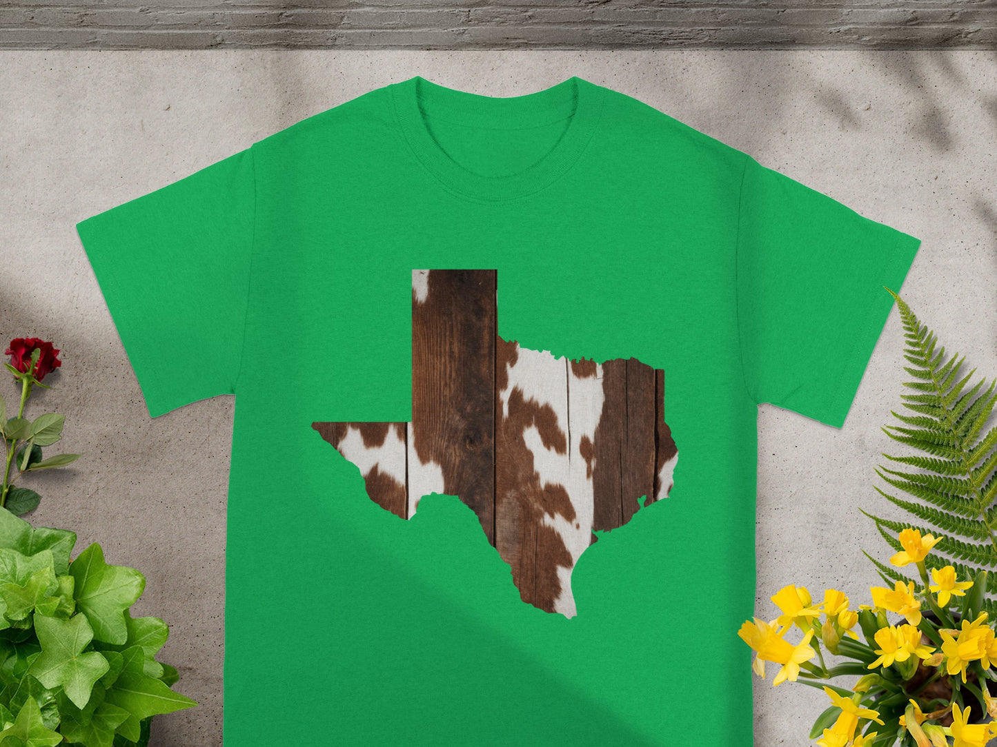 Green t-shirt with Texas shape filled with cowhide and wood pattern.