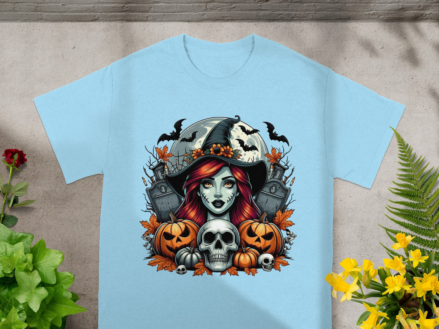 Halloween t-shirt design with a witch, pumpkins, skull, bats, and gravestones.