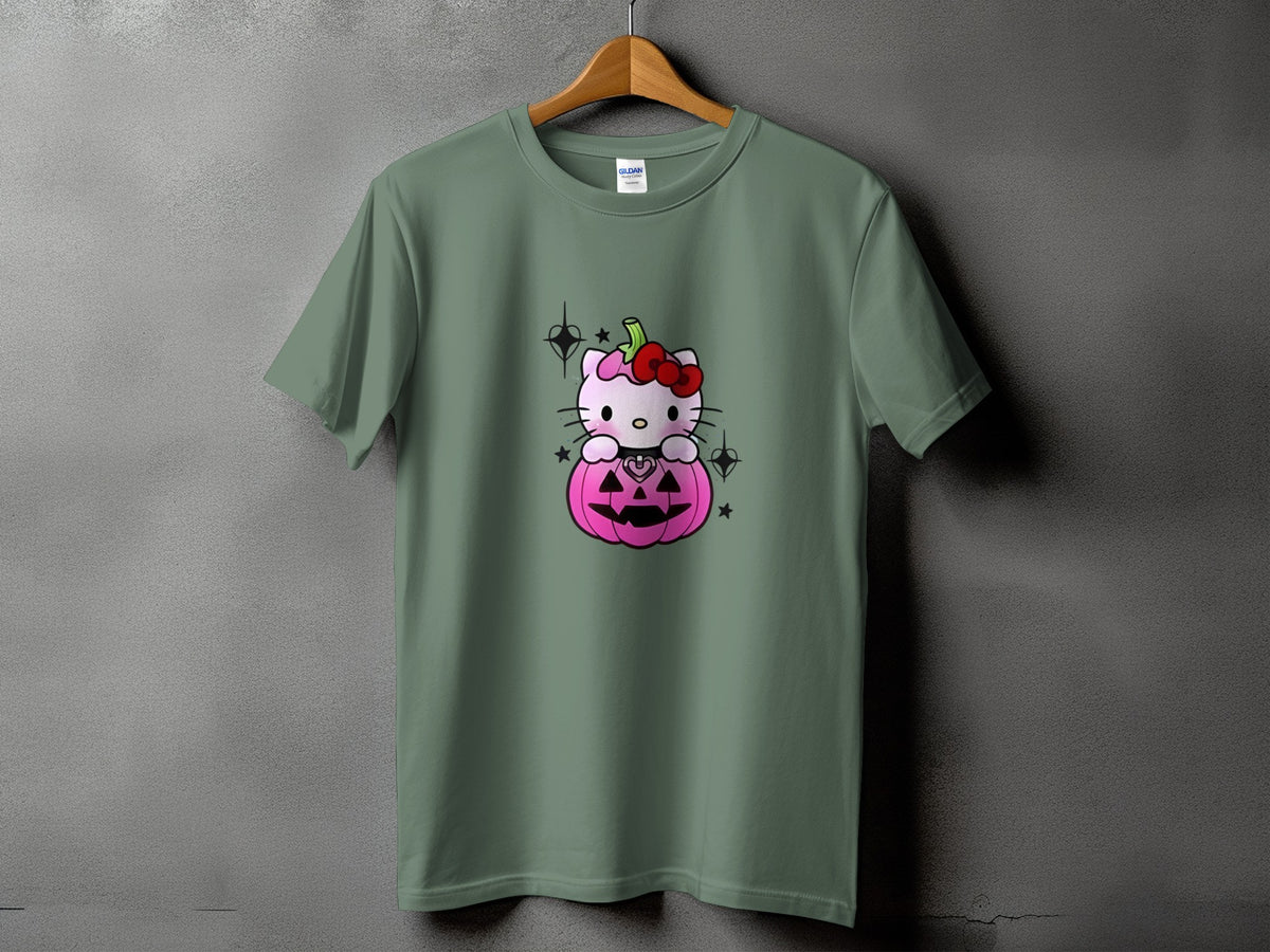 Hello Kitty sits on a pink pumpkin with a red bow, on a green t-shirt.