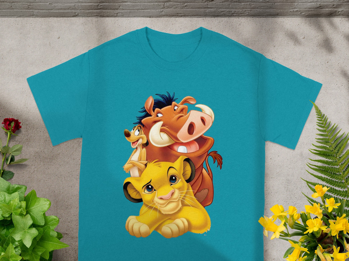 The Lion King characters Timon, Pumbaa, and Simba on a turquoise t-shirt.