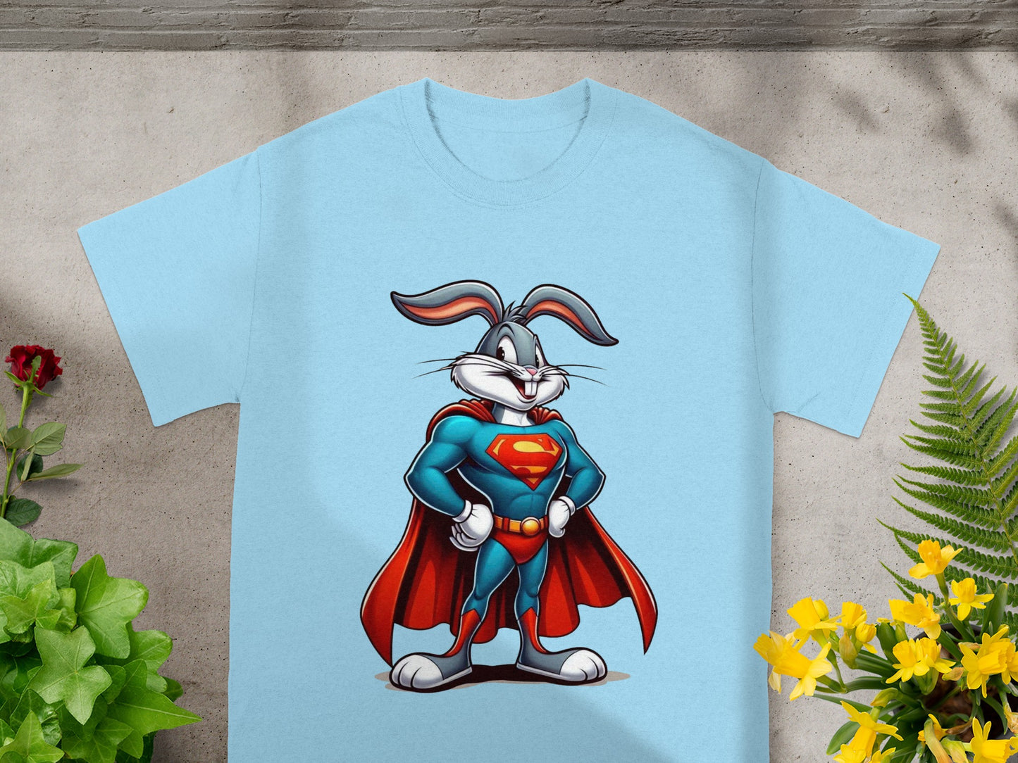 Bugs Bunny in a Superman costume posing with hands on hips on a light blue t-shirt.
