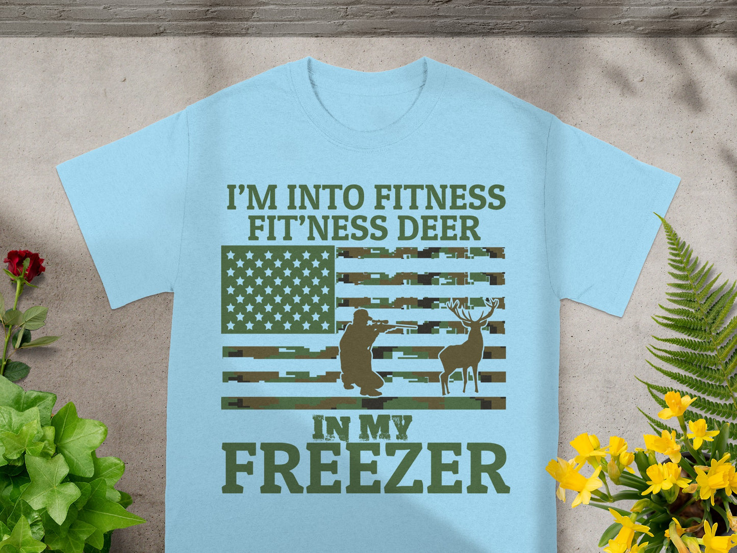 Light blue t-shirt with "I'M INTO FITNESS FIT'NESS DEER IN MY FREEZER" text and patriotic design.