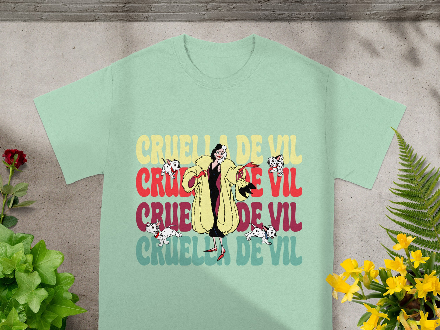 Cruella de Vil graphic t-shirt with puppies and floral accents.