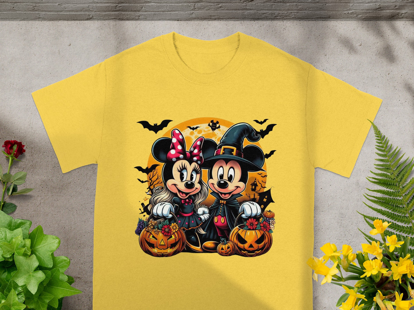 Mickey and Minnie Mouse in Halloween costumes with pumpkins and bats on a yellow t-shirt.