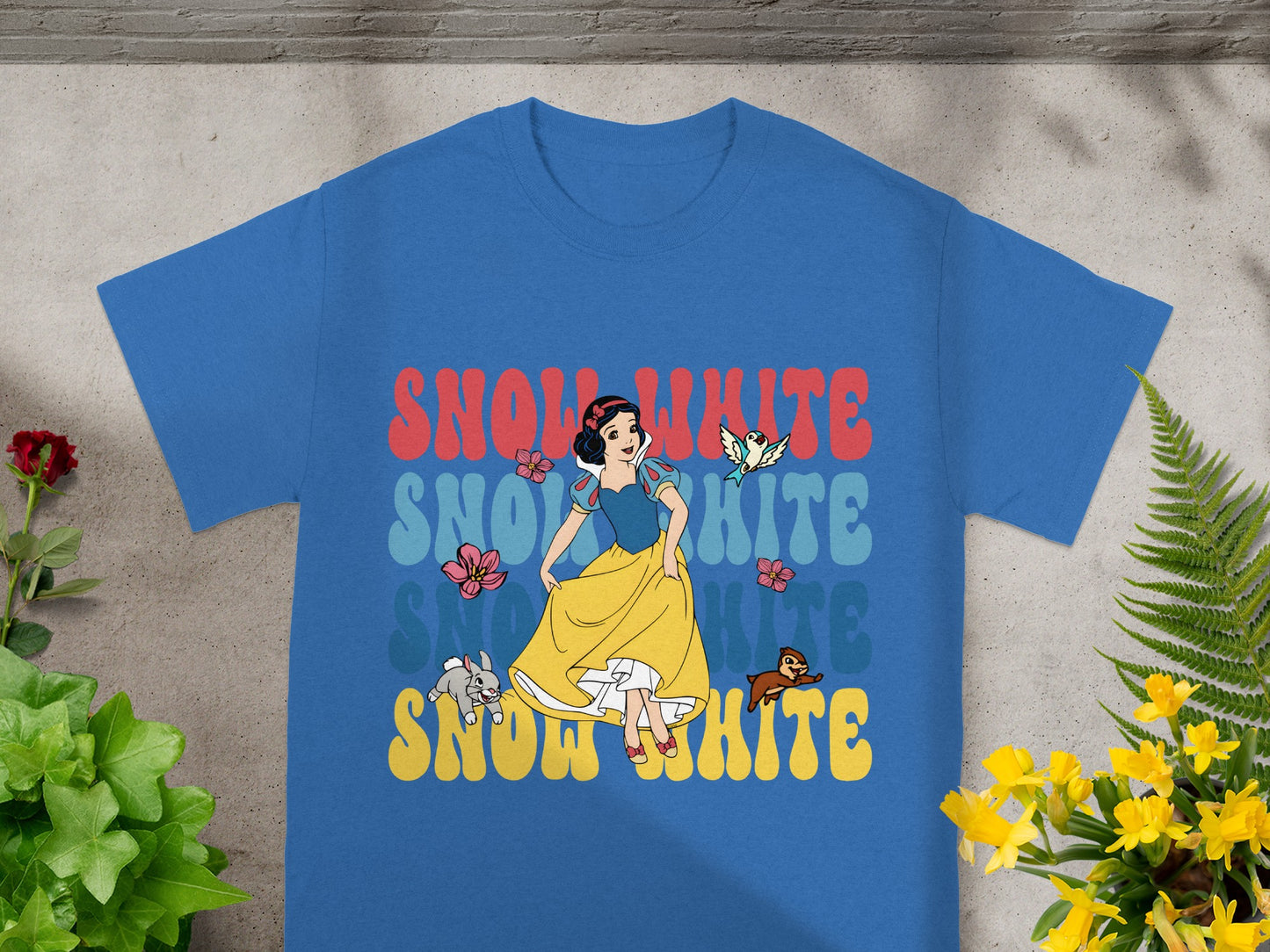 Blue t-shirt with "Snow White" text in colorful retro lettering and character graphics.