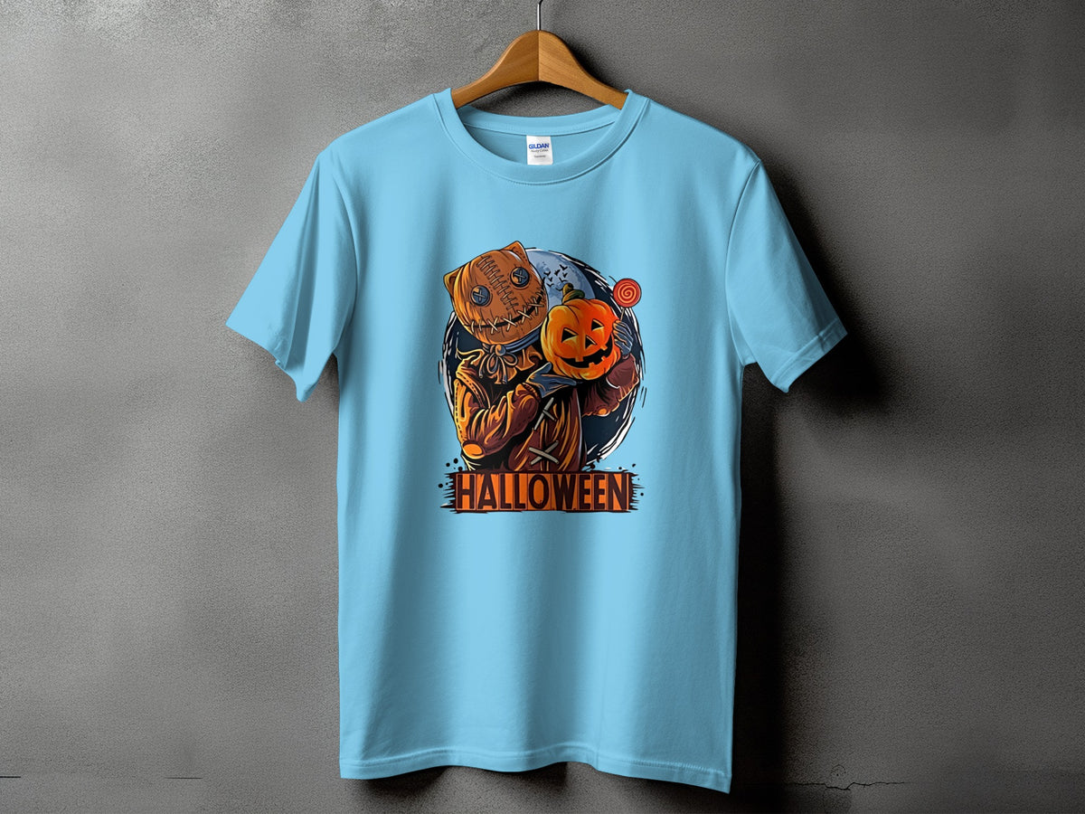 Light blue t-shirt with a burlap-headed scarecrow holding a pumpkin and lollipop.