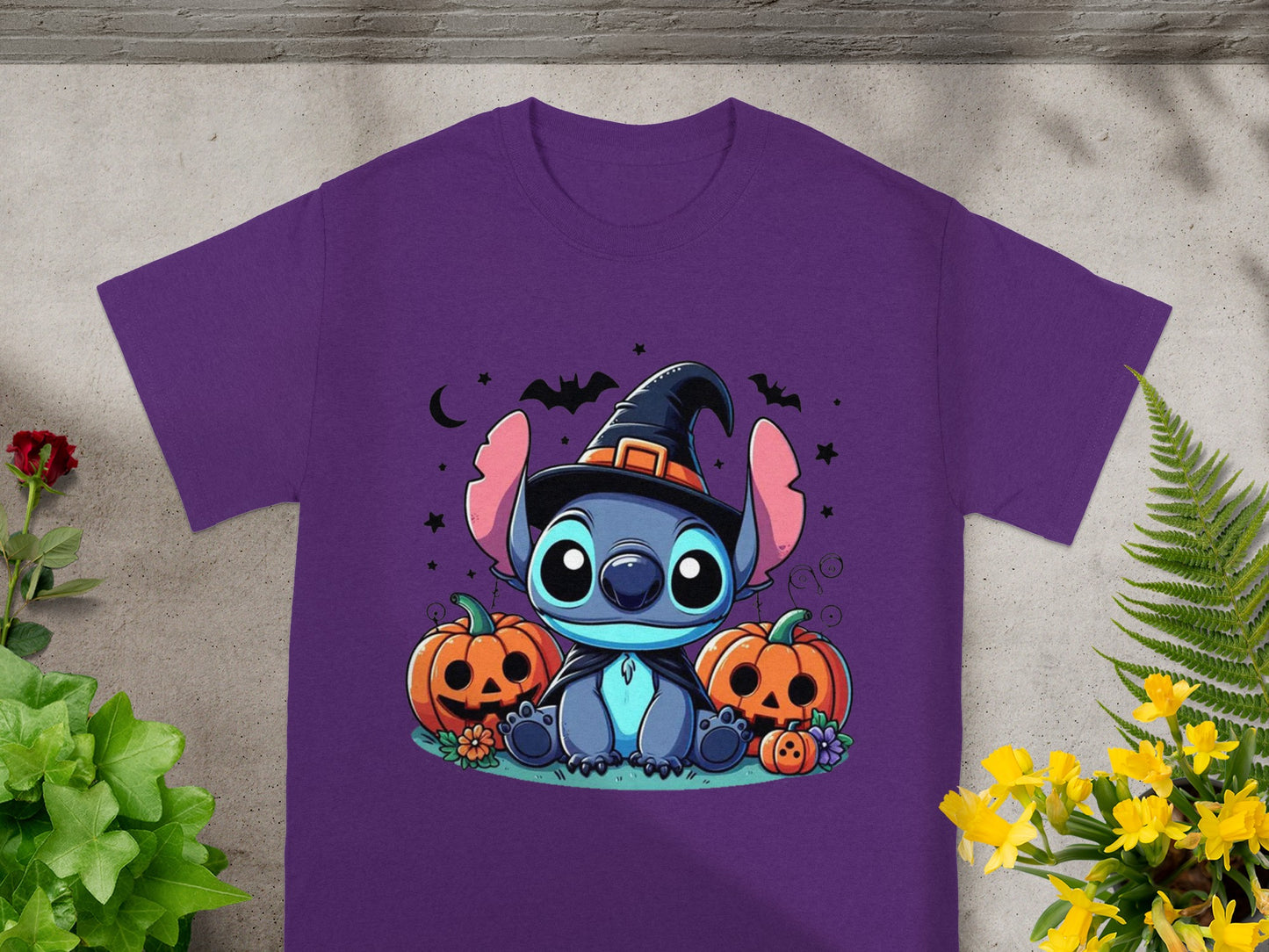 Stitch wearing a witch hat with pumpkins and bats on a purple t-shirt.