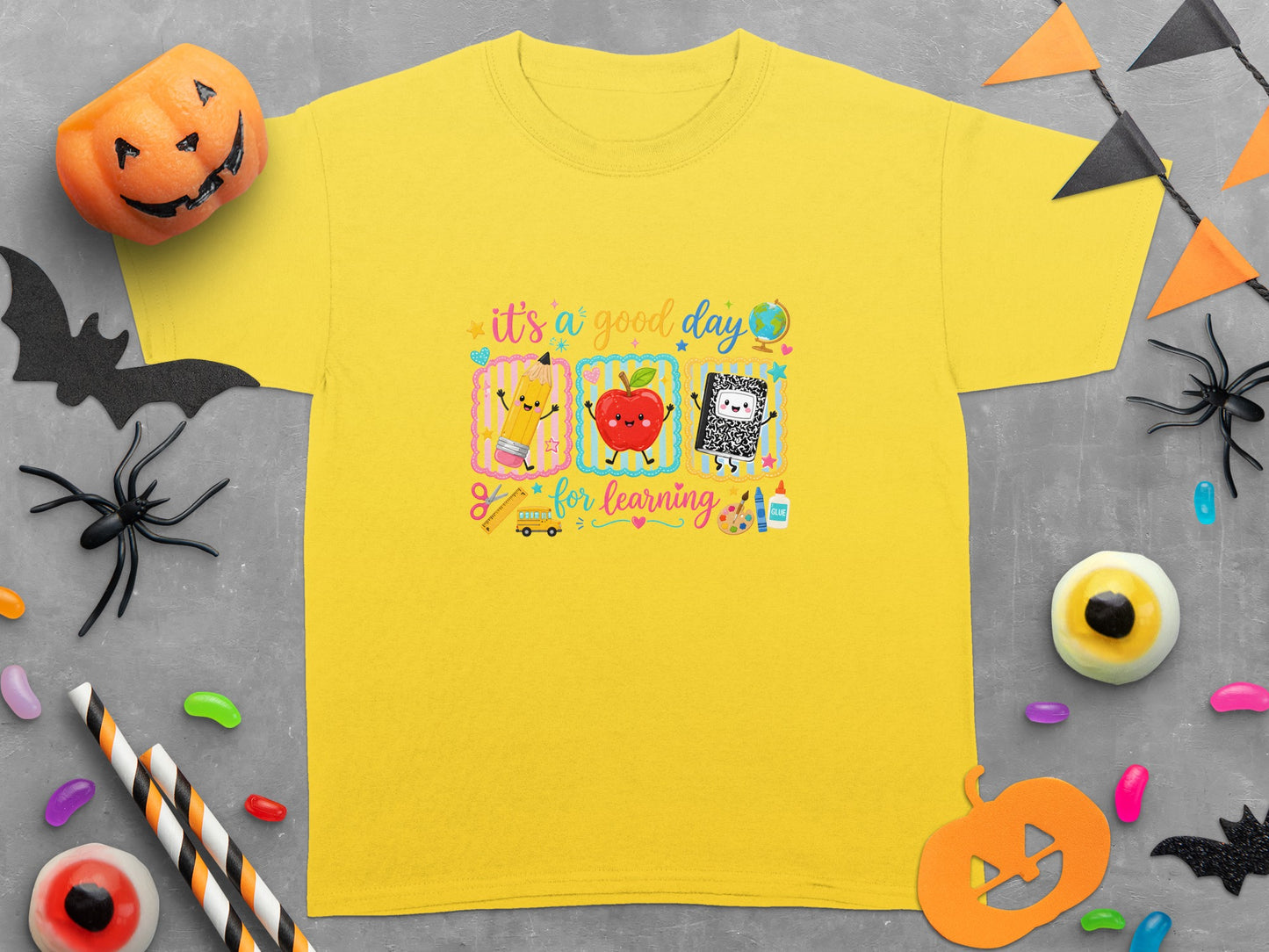 Yellow t-shirt with "It's a good day for learning" graphic featuring school items.