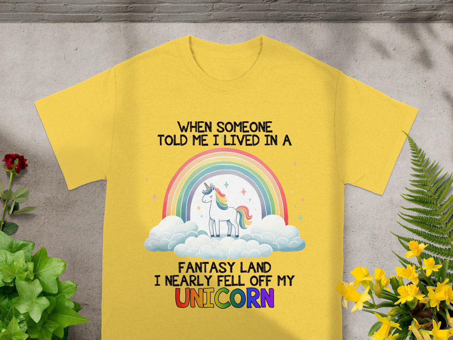 Yellow t-shirt with text "When someone told me I lived in a fantasy land I nearly fell off my UNICORN," and a unicorn graphic.