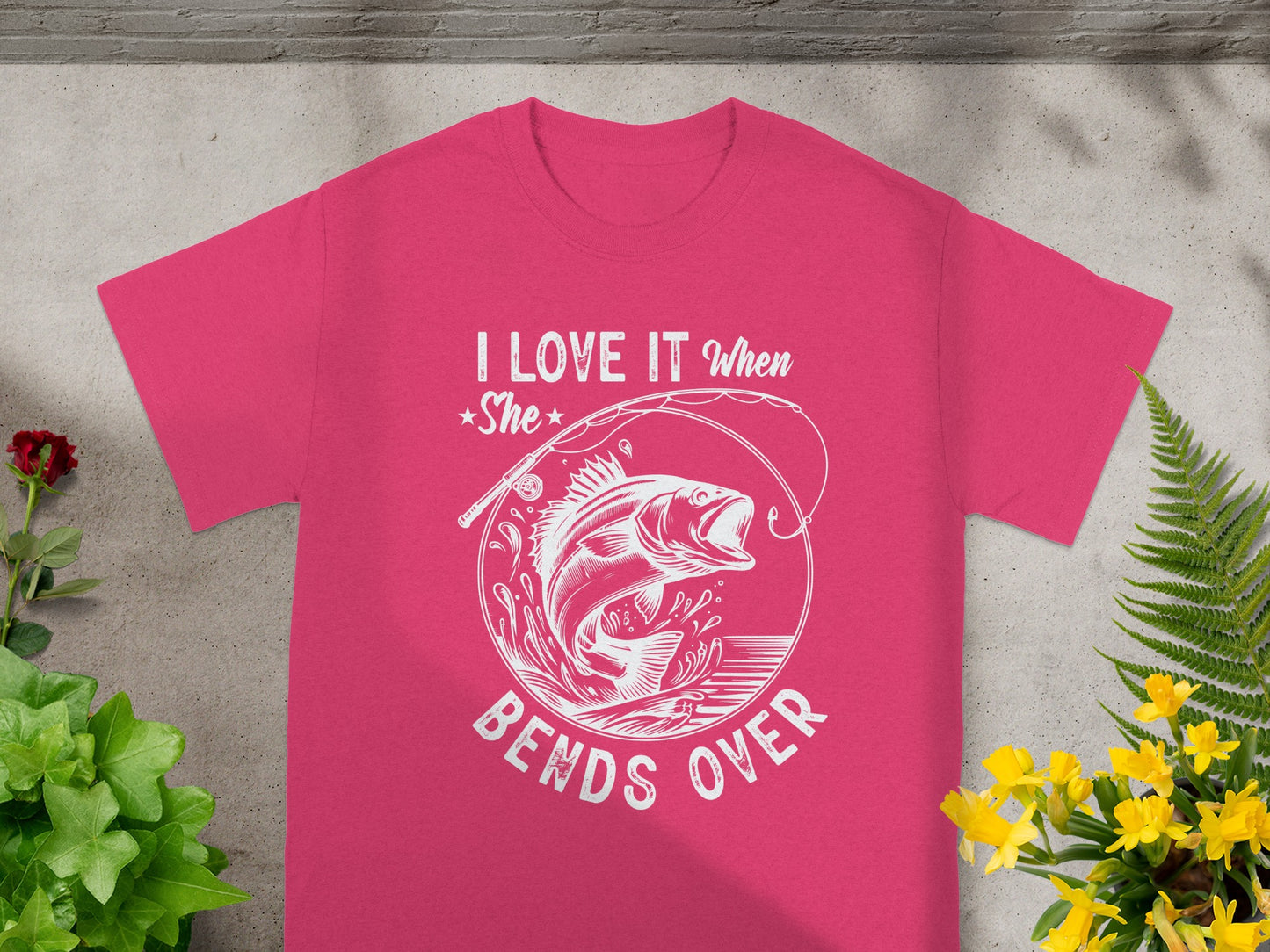 Pink t-shirt with white text and graphic of a fish jumping from water.