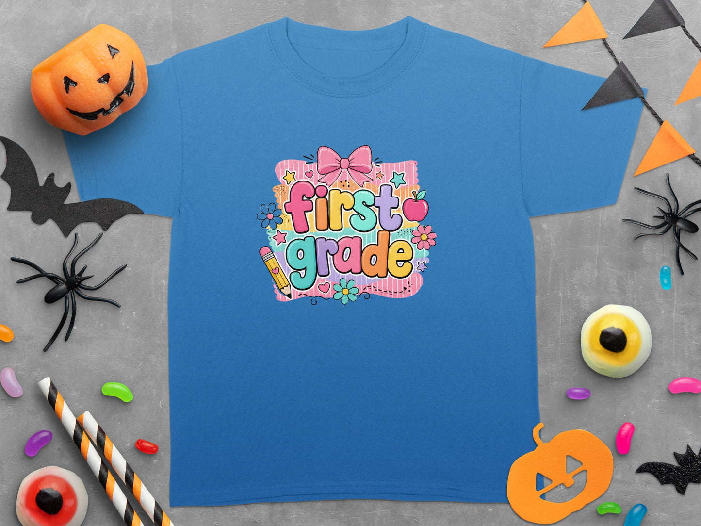 Blue t-shirt with "First Grade" graphic and Halloween-themed decorations.