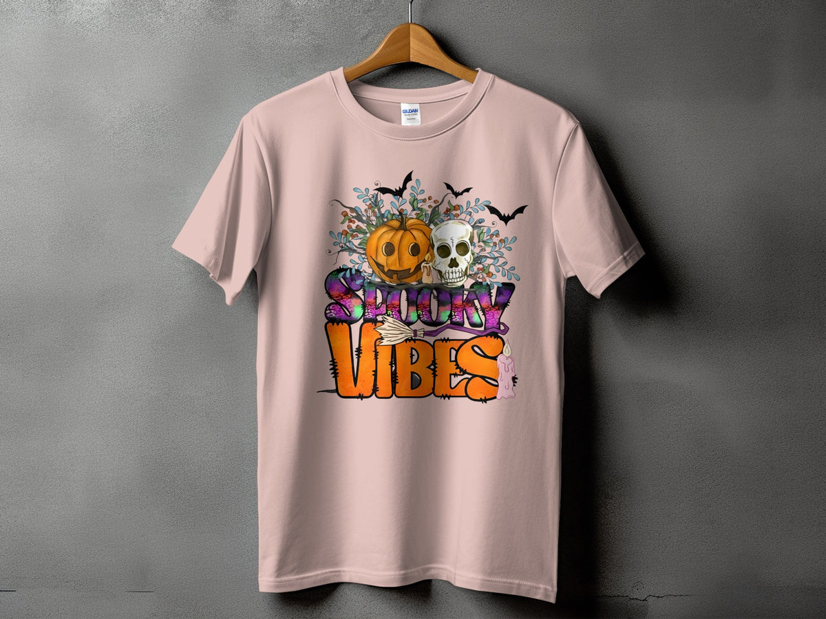 Pink t-shirt with "Spooky Vibes" Halloween graphic featuring pumpkin, skull, bats, and broom.