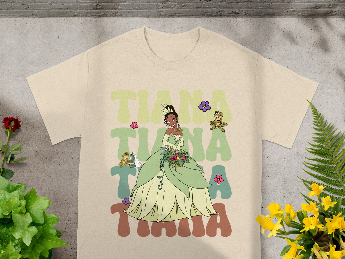 Tiana from The Princess and the Frog in her green ballgown, with cartoon frog and flowers.