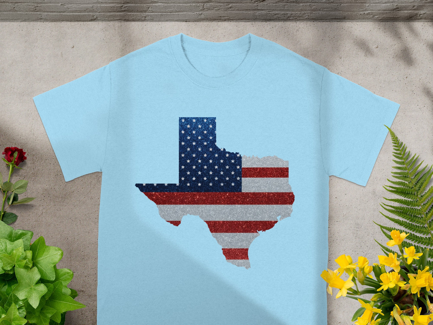 Light blue t-shirt with Texas map outline in American flag colors and glitter.