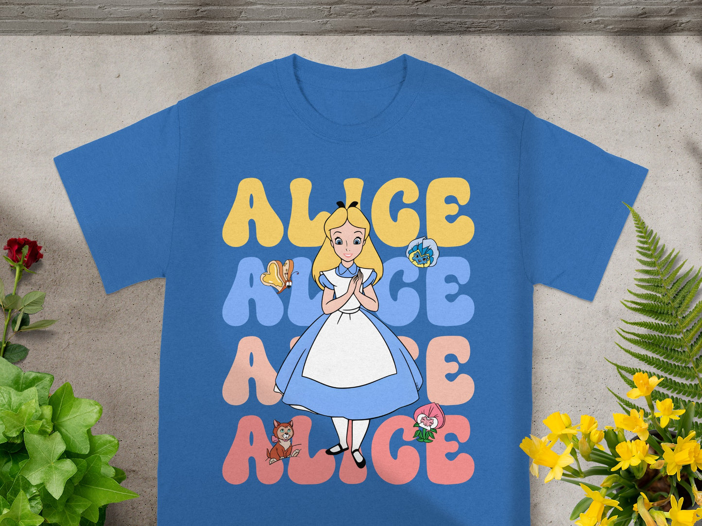 Blue t-shirt with Alice in Wonderland characters and text.