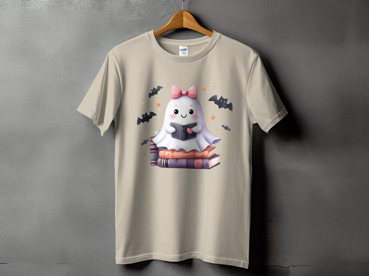 Tan t-shirt with a cute ghost reading a book, surrounded by bats.