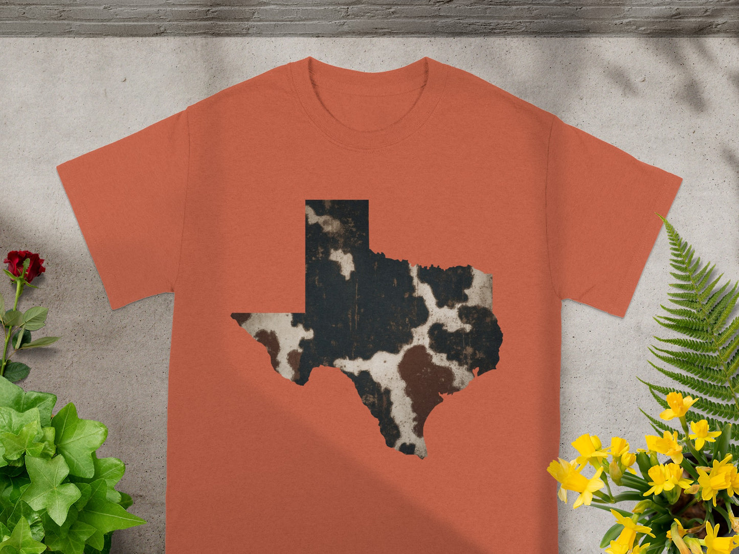 Orange t-shirt with a distressed cowhide Texas shape graphic.