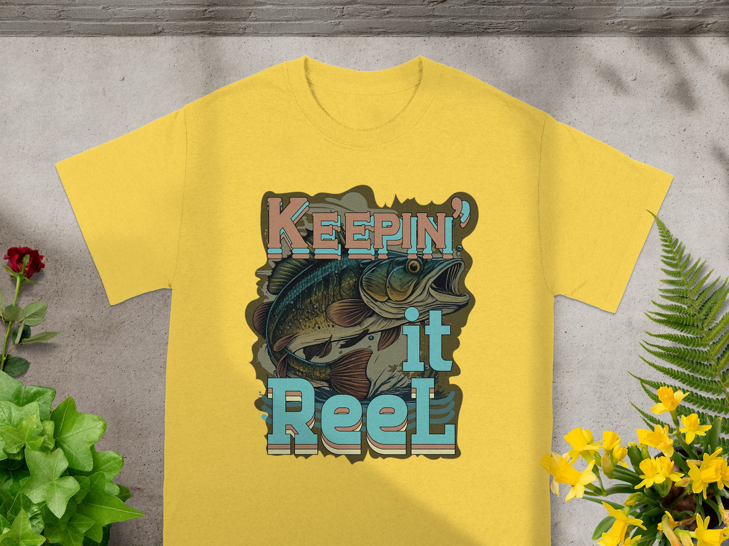 Yellow t-shirt with a bass fish and text reading "KEEPING it Reel."