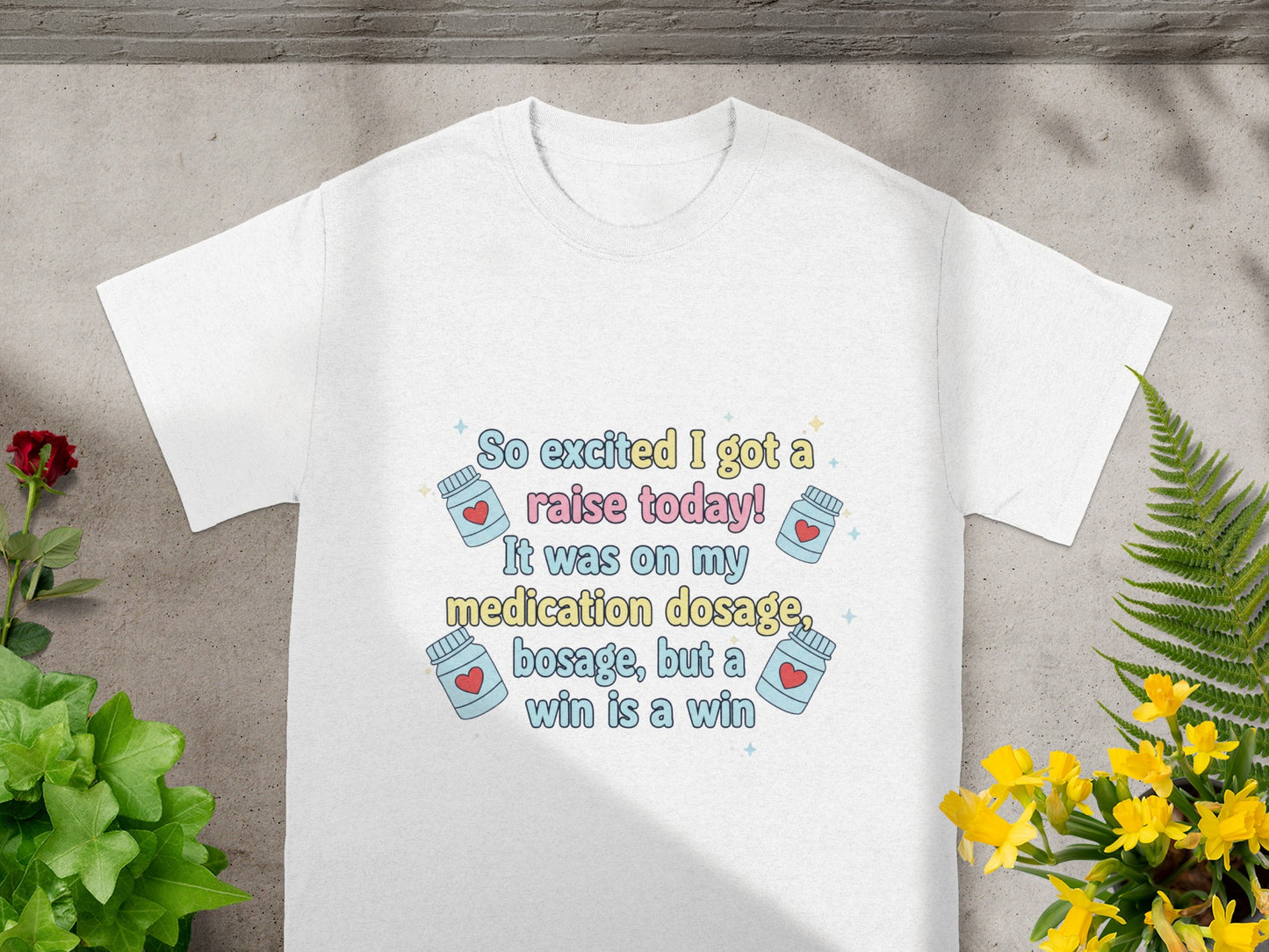 White t-shirt with text "So excited I got a raise today! It was on my medication dosage, but a win is a win."