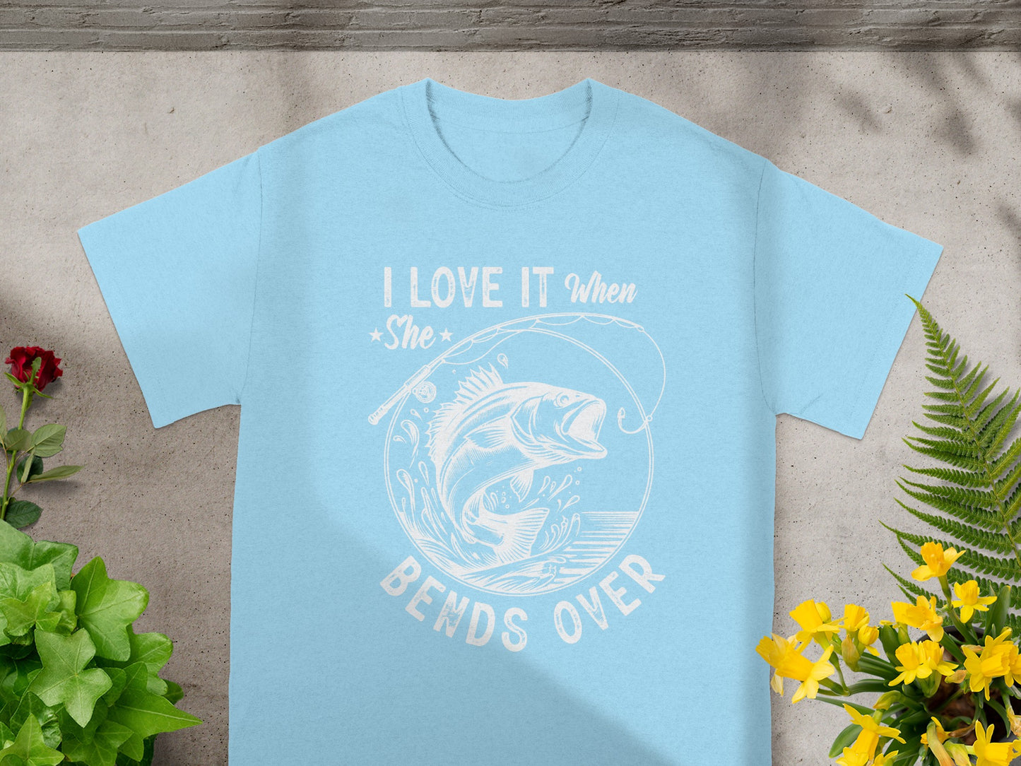 Light blue t-shirt with text "I LOVE IT When She BENDS OVER" and a jumping fish graphic.